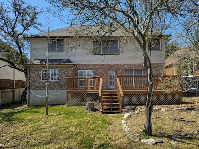 rear view of property featuring fence, stairs, a deck, a lawn, and brick siding