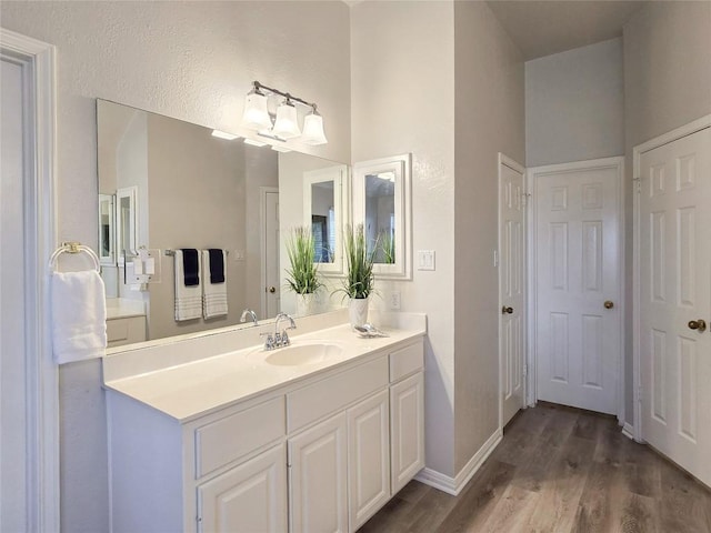 bathroom with vanity, wood finished floors, and baseboards