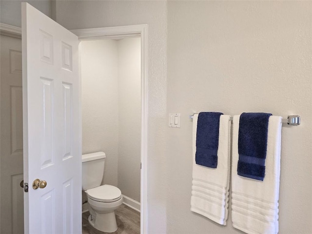 bathroom with baseboards and toilet