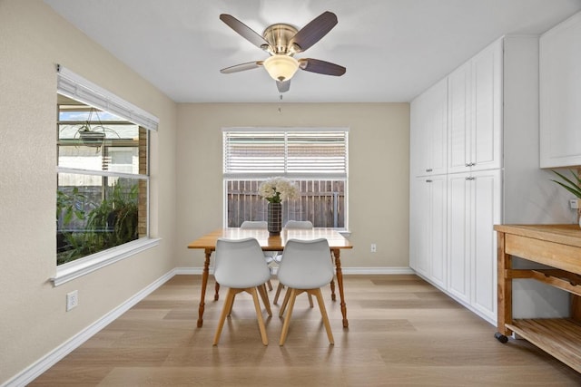 dining space featuring light wood-style flooring, plenty of natural light, baseboards, and ceiling fan