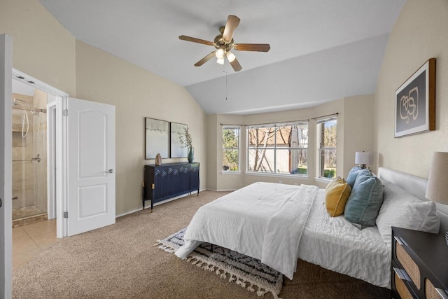 carpeted bedroom featuring tile patterned flooring, vaulted ceiling, ensuite bathroom, and ceiling fan