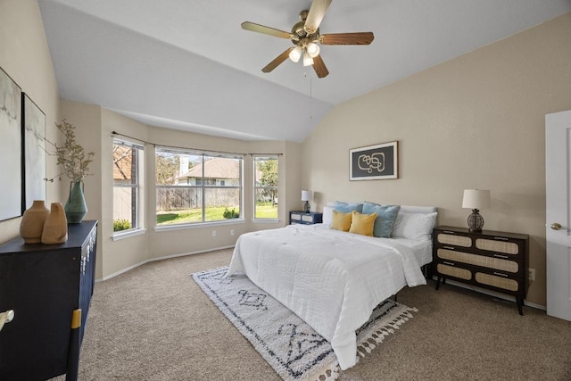 carpeted bedroom with vaulted ceiling, baseboards, and ceiling fan