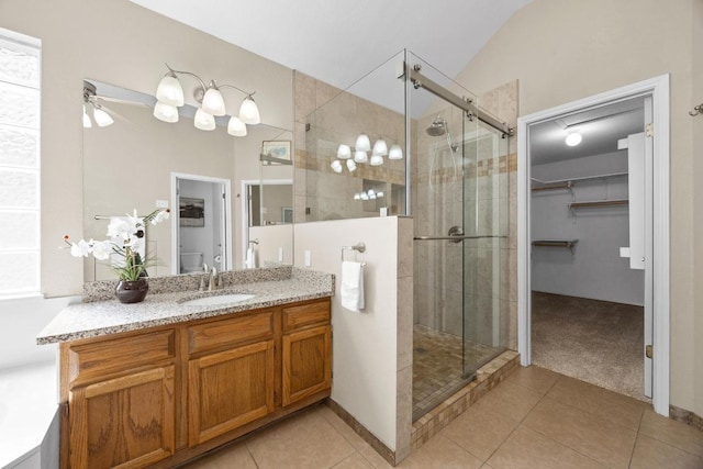 bathroom with tile patterned floors, vanity, a spacious closet, and a shower stall