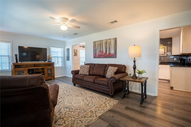 living area with visible vents, plenty of natural light, and dark wood-style flooring