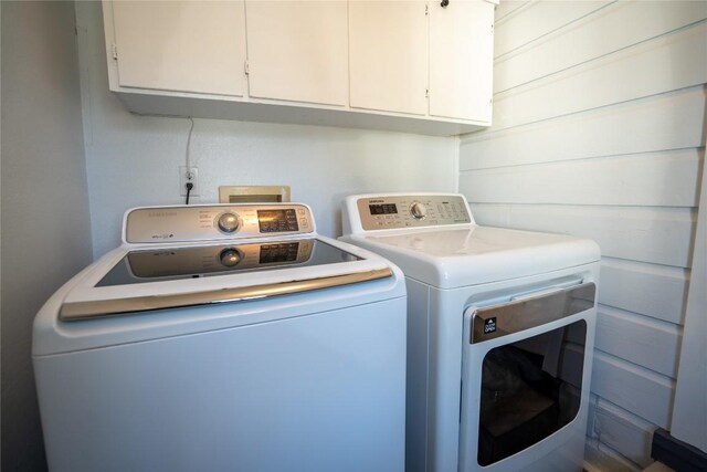 washroom with cabinet space and washing machine and dryer