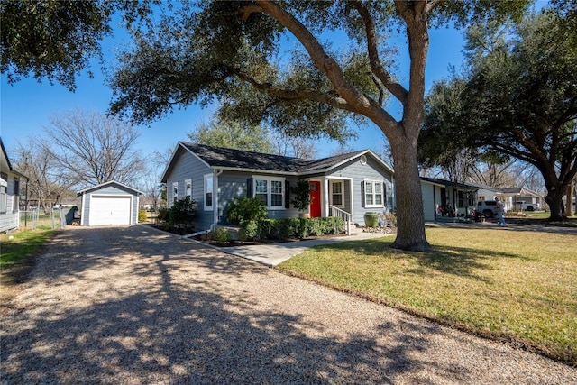 ranch-style home featuring a garage, driveway, a front yard, and an outdoor structure