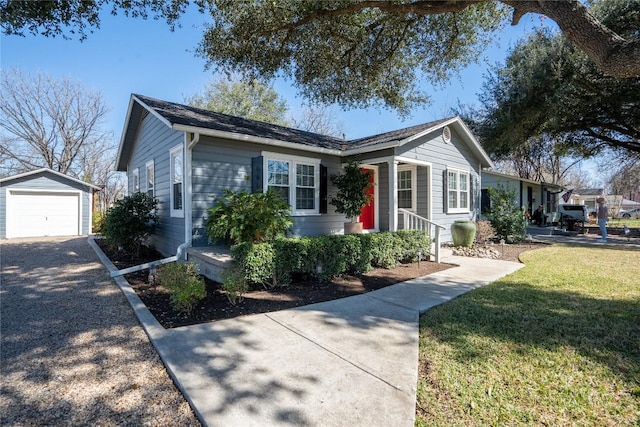 single story home with an outbuilding, driveway, a front lawn, and a detached garage