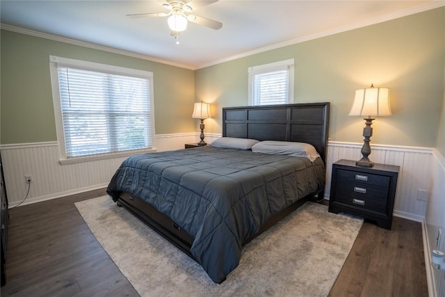 bedroom featuring a wainscoted wall, wood finished floors, and crown molding