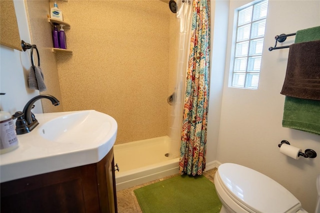 bathroom featuring vanity, toilet, and a stall shower