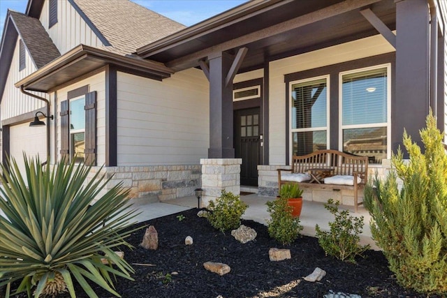 107 Freeman Day Dr, Bastrop, TX 78602 - view of exterior entry featuring covered porch, a shingled roof, board and batten siding, and a garage