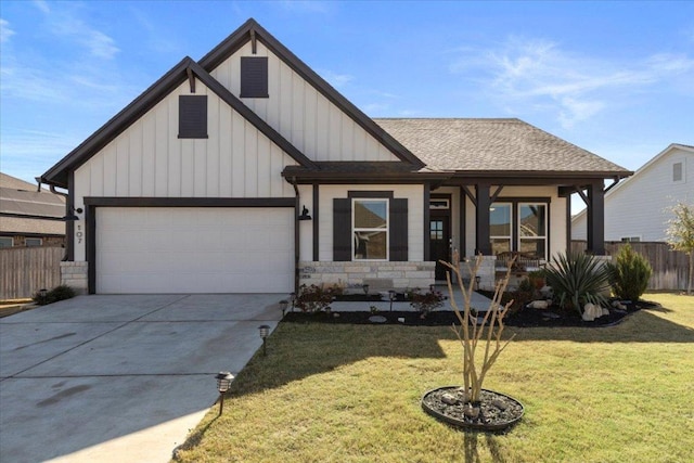 view of front of house featuring a shingled roof, a front lawn, fence, a garage, and driveway