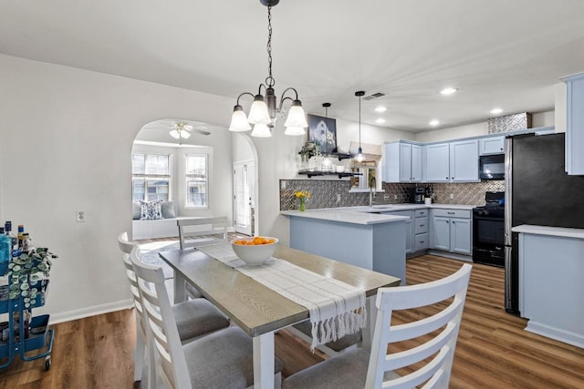 dining space featuring recessed lighting, visible vents, arched walkways, and dark wood-type flooring