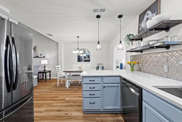 kitchen featuring light wood-type flooring, visible vents, open shelves, stainless steel appliances, and a peninsula