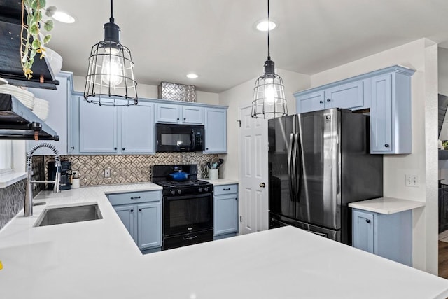 kitchen featuring backsplash, black appliances, light countertops, and a sink