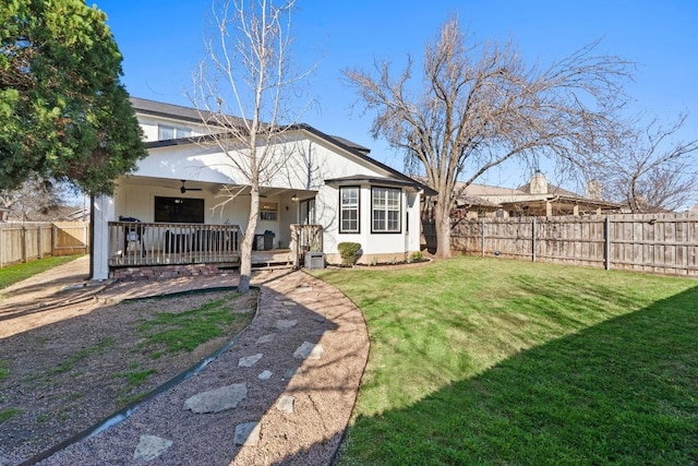 back of house featuring a ceiling fan, a yard, a fenced backyard, covered porch, and stucco siding