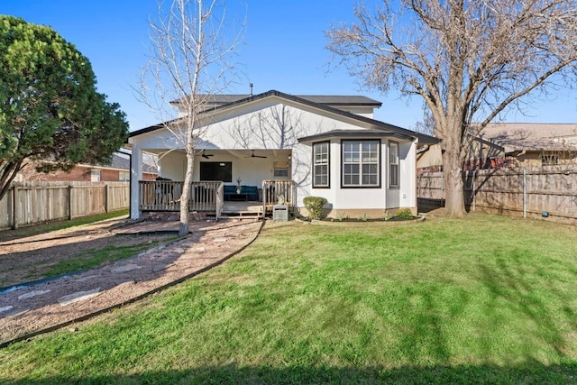 rear view of property featuring a yard, a fenced backyard, and ceiling fan