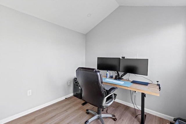 office space featuring baseboards, wood finished floors, and vaulted ceiling