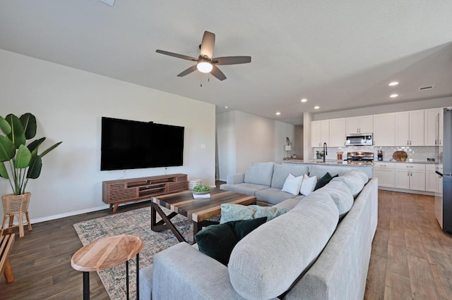 living room featuring recessed lighting, ceiling fan, baseboards, and wood finished floors