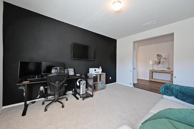 carpeted office featuring visible vents and baseboards