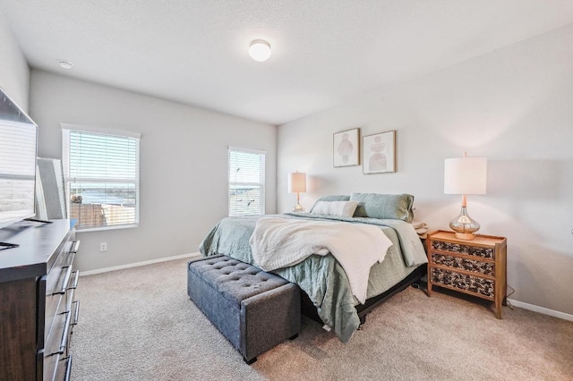 bedroom with light colored carpet and baseboards