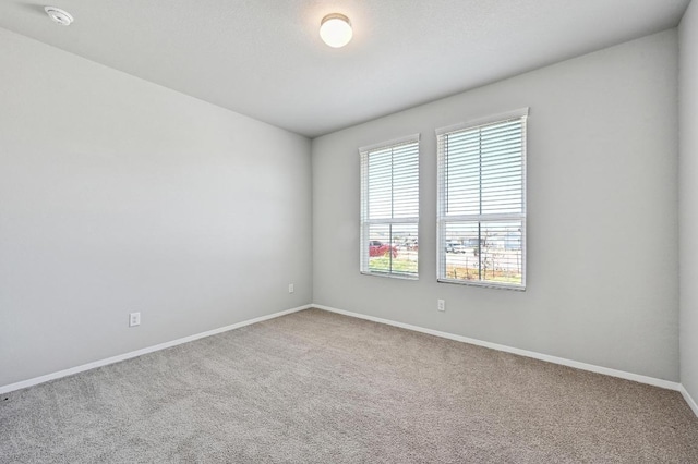 carpeted empty room with baseboards