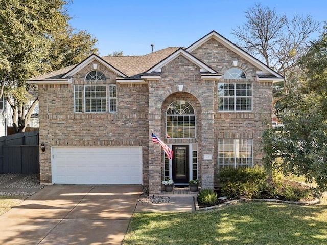 traditional home with a garage, brick siding, concrete driveway, and fence