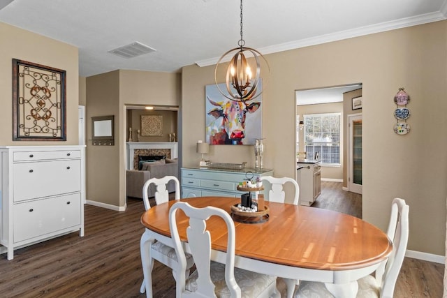 dining area with visible vents, a fireplace, crown molding, baseboards, and dark wood-style flooring