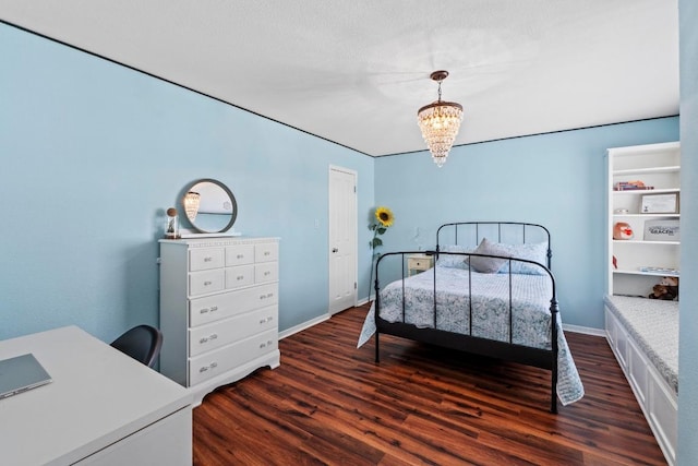 bedroom with a notable chandelier, baseboards, and dark wood-style flooring