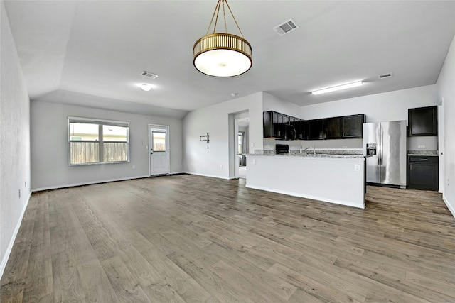 unfurnished living room featuring light wood-style flooring, baseboards, and visible vents