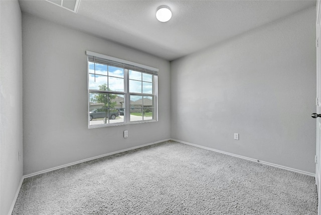 spare room featuring visible vents, a textured ceiling, and baseboards