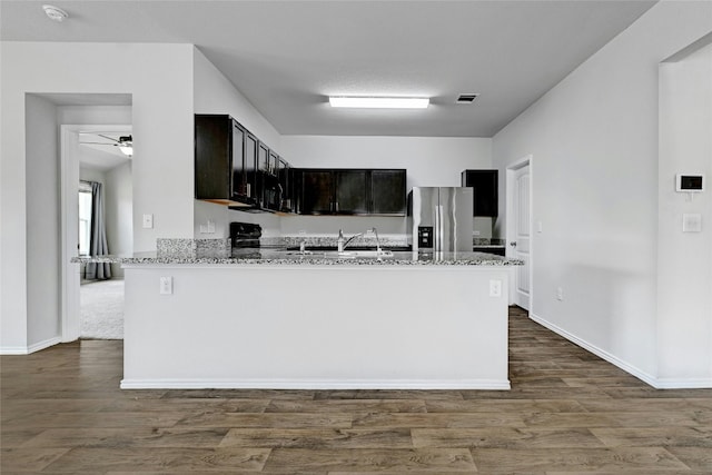 5800 Shanjia Dr, Austin, TX 78724 - kitchen with black appliances, light stone counters, dark wood-style floors, and a sink