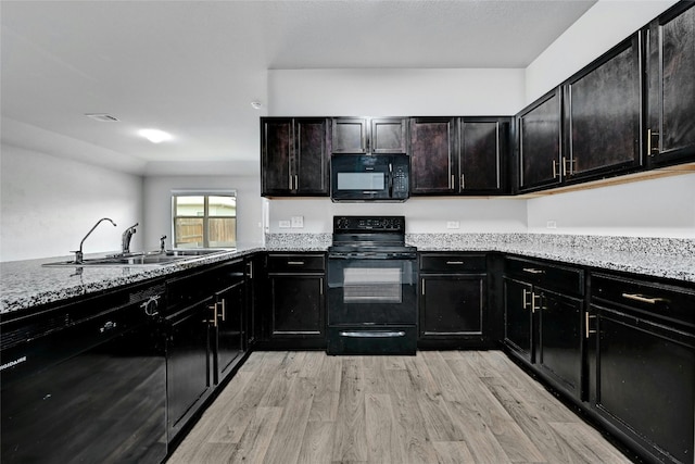 5800 Shanjia Dr, Austin, TX 78724 - kitchen with black appliances, light wood-type flooring, a sink, and light stone counters