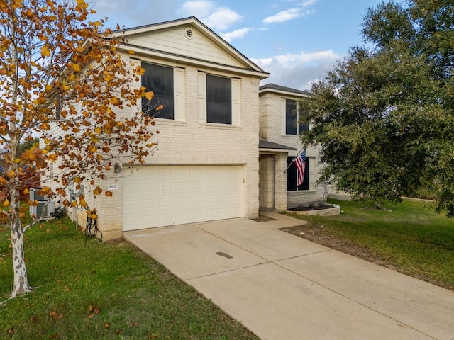 traditional-style house with a garage, brick siding, concrete driveway, and a front yard