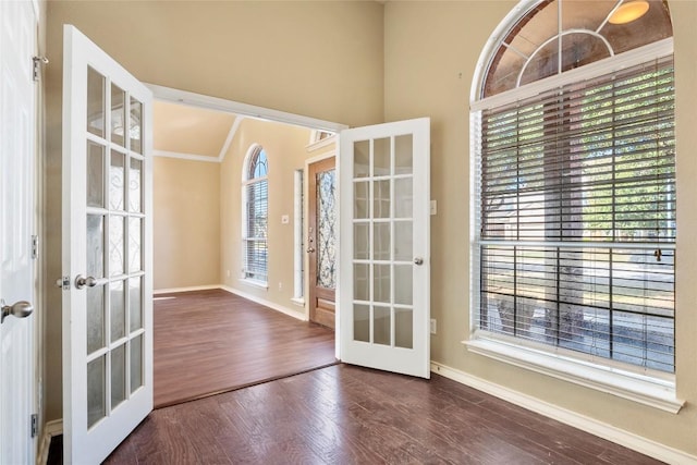 doorway with wood finished floors, french doors, baseboards, and ornamental molding