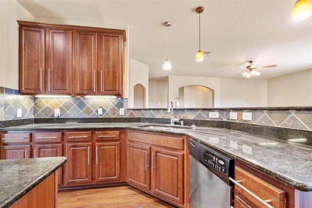 kitchen featuring dishwasher, pendant lighting, decorative backsplash, light wood-style floors, and a sink