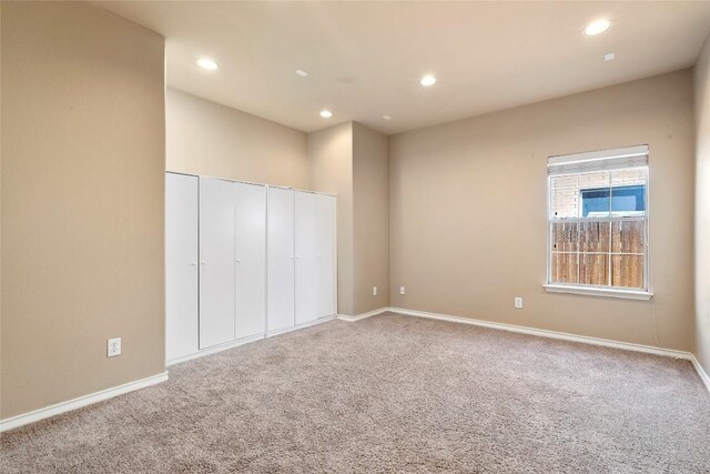 unfurnished bedroom featuring recessed lighting, a closet, baseboards, and carpet flooring