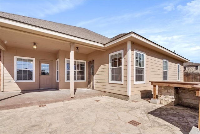 exterior space with roof with shingles and a patio area