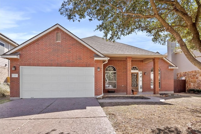 single story home featuring a garage, brick siding, driveway, and a shingled roof