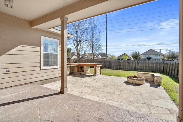 view of patio with a residential view, a fire pit, and a fenced backyard