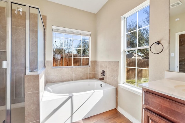 bathroom with vanity, wood finished floors, visible vents, a shower stall, and a garden tub