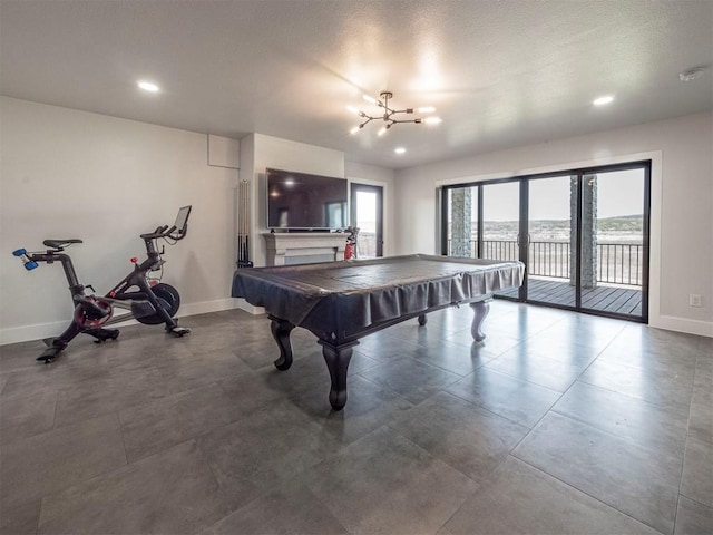 game room featuring a chandelier, a fireplace, french doors, and baseboards