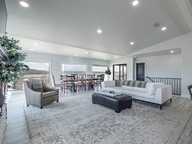 living room featuring wood finished floors, recessed lighting, and vaulted ceiling