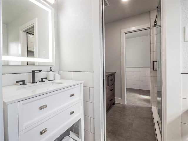 bathroom with vanity, a shower stall, and concrete flooring