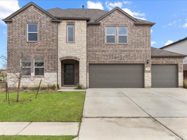 traditional home with a front yard, a shingled roof, concrete driveway, stone siding, and brick siding