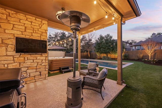 patio terrace at dusk with a lawn, area for grilling, a fenced backyard, a fenced in pool, and a hot tub