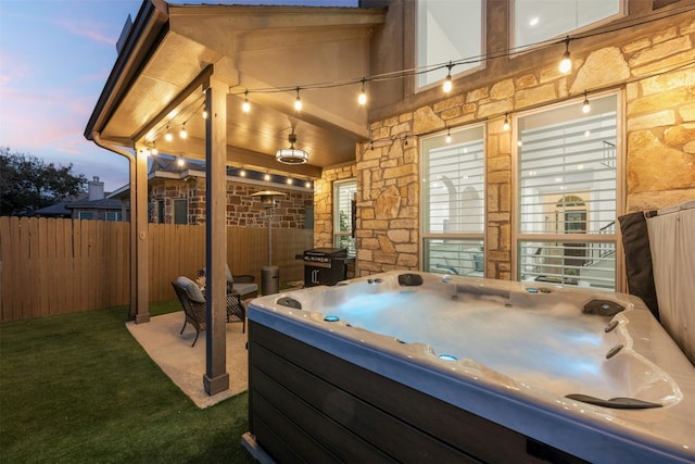 view of patio / terrace featuring grilling area, a hot tub, and fence