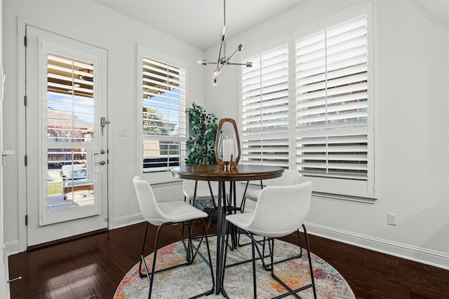 dining space featuring a notable chandelier, baseboards, and dark wood-style flooring