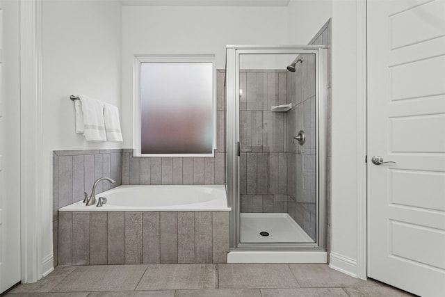 bathroom featuring a shower stall, a garden tub, and tile patterned floors