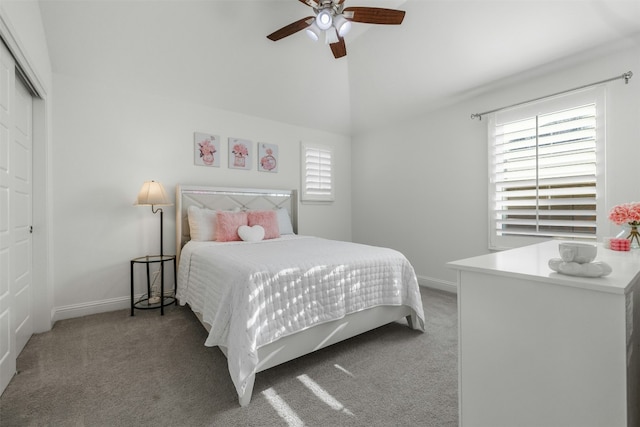 carpeted bedroom with lofted ceiling, baseboards, a closet, and ceiling fan