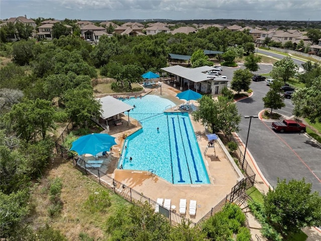 view of swimming pool featuring a residential view and fence